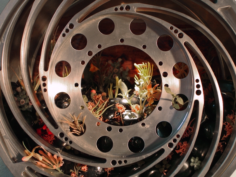 E.V. Day, Wheel Of Optimism (detai),&nbsp;Milled aluminum tire from NASA Mars Rover,&nbsp;hematite rocks, artificial plants and photo.&nbsp;9 x 9 x 8 inches., Commissioned by NASA, Mars Exploration Program, Jet Propulsion Laboratory, Pasadena, CA.